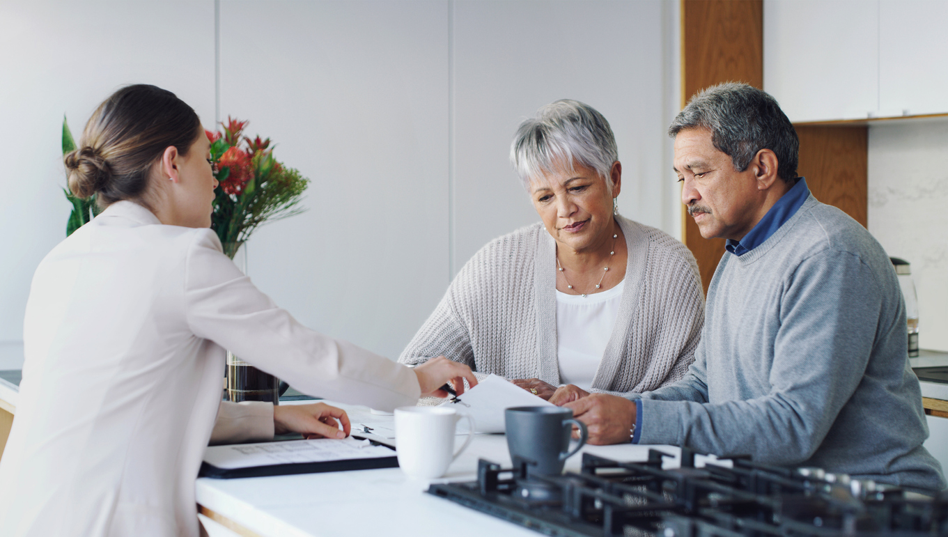 Shot of a senior couple meeting with an agent to discuss paperwork at home