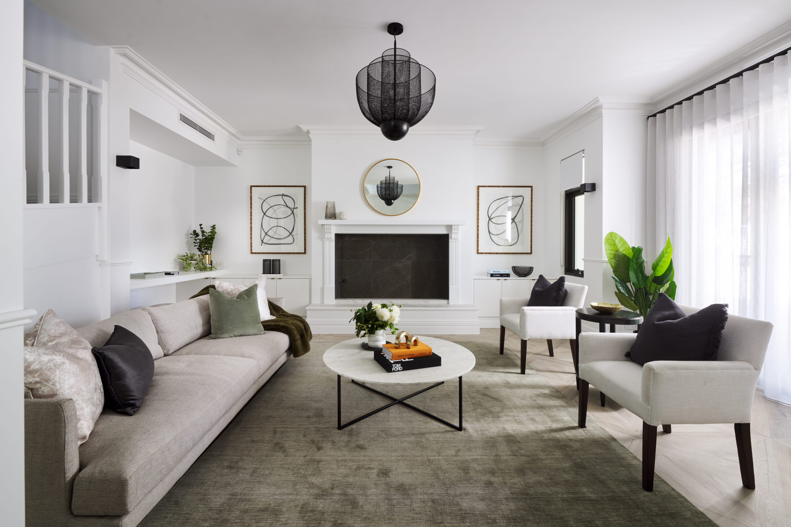 Formal living room in a custom Perth home with ornate fireplace surround, black mesh pendant light and neutral furnishings.