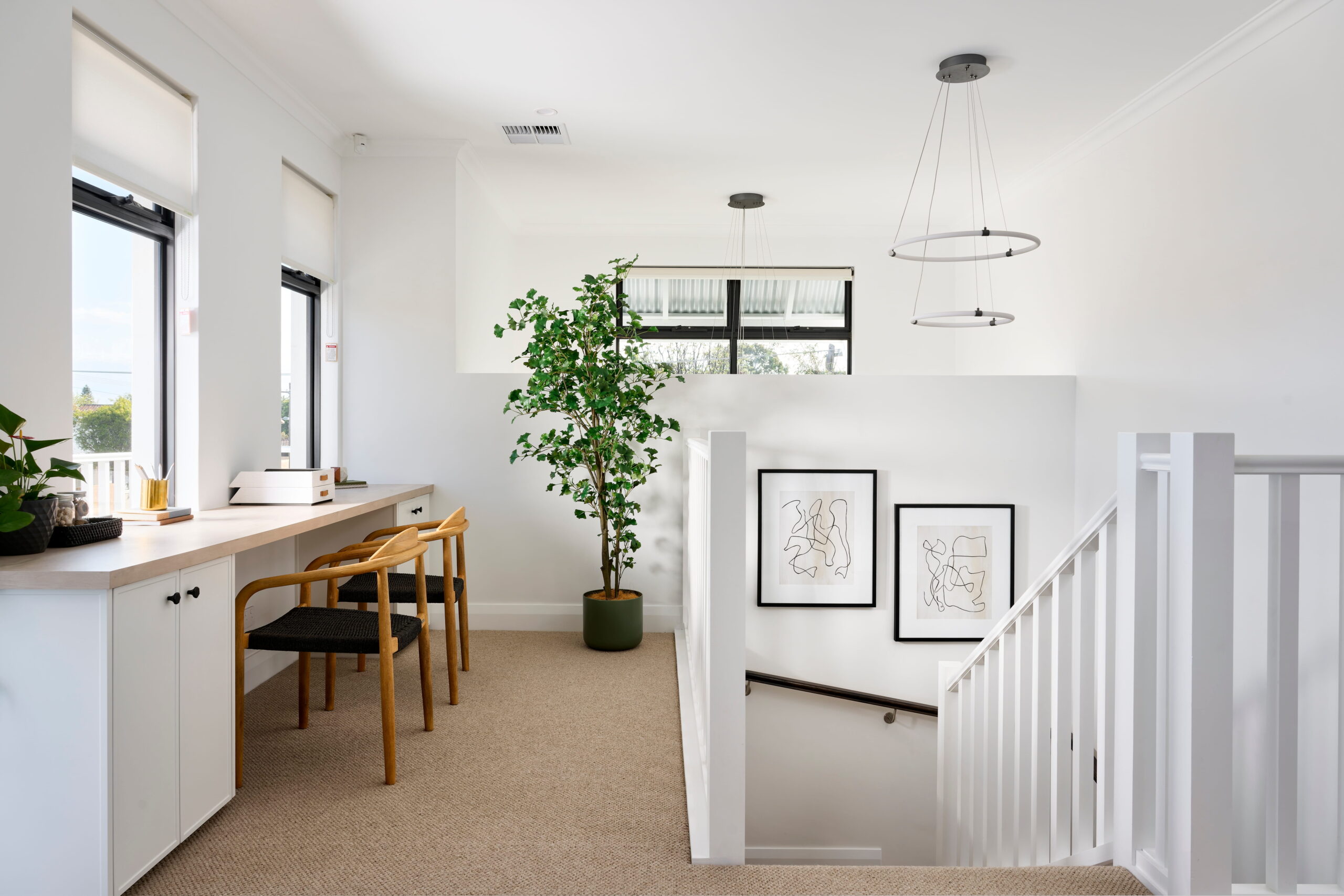 Upper-level study nook in a two-storey custom Perth home with built-in desk, neutral carpet, ring pendant light and staircase landing.