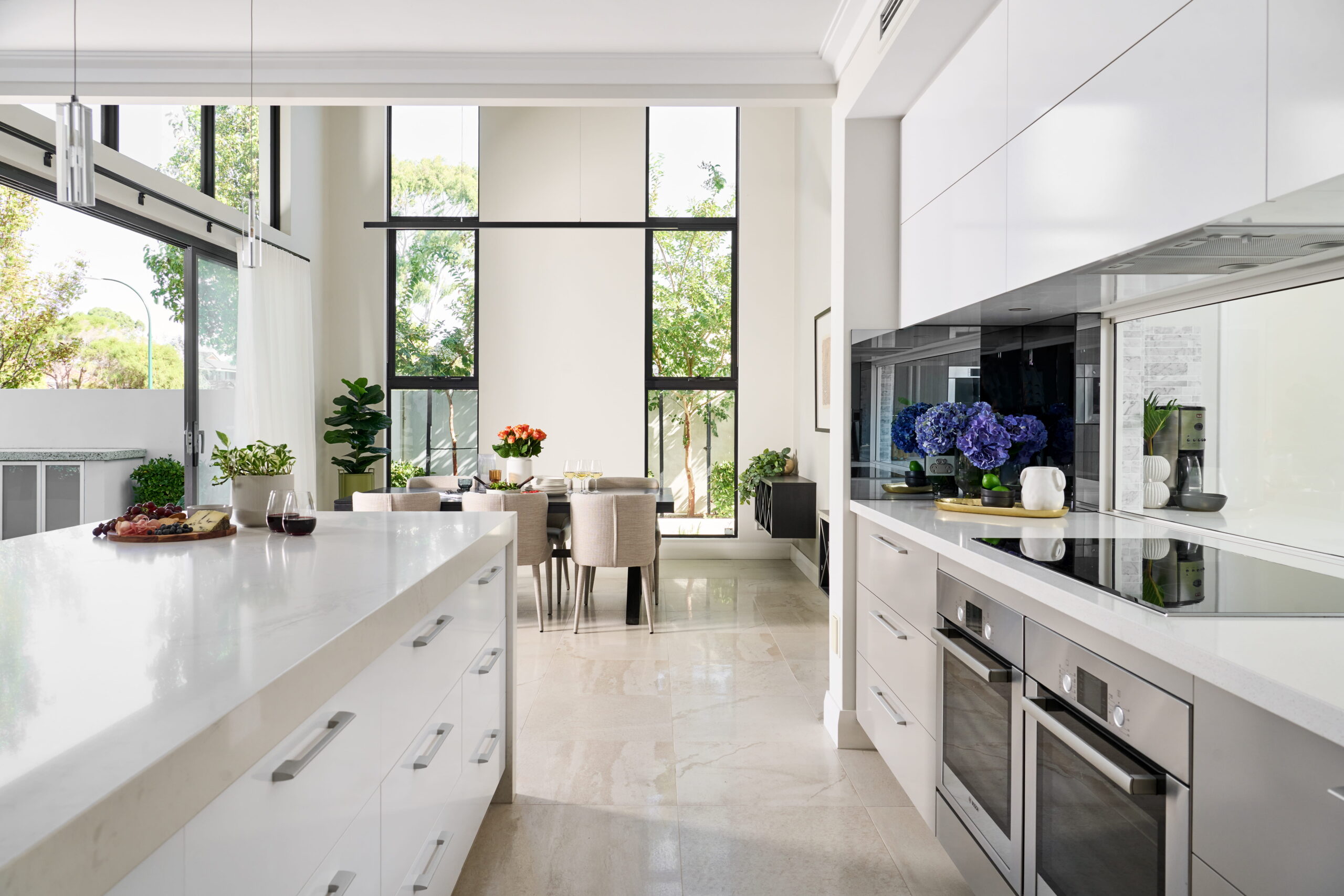Light-filled open-plan living and kitchen with full-height sliding glazing and double-height void