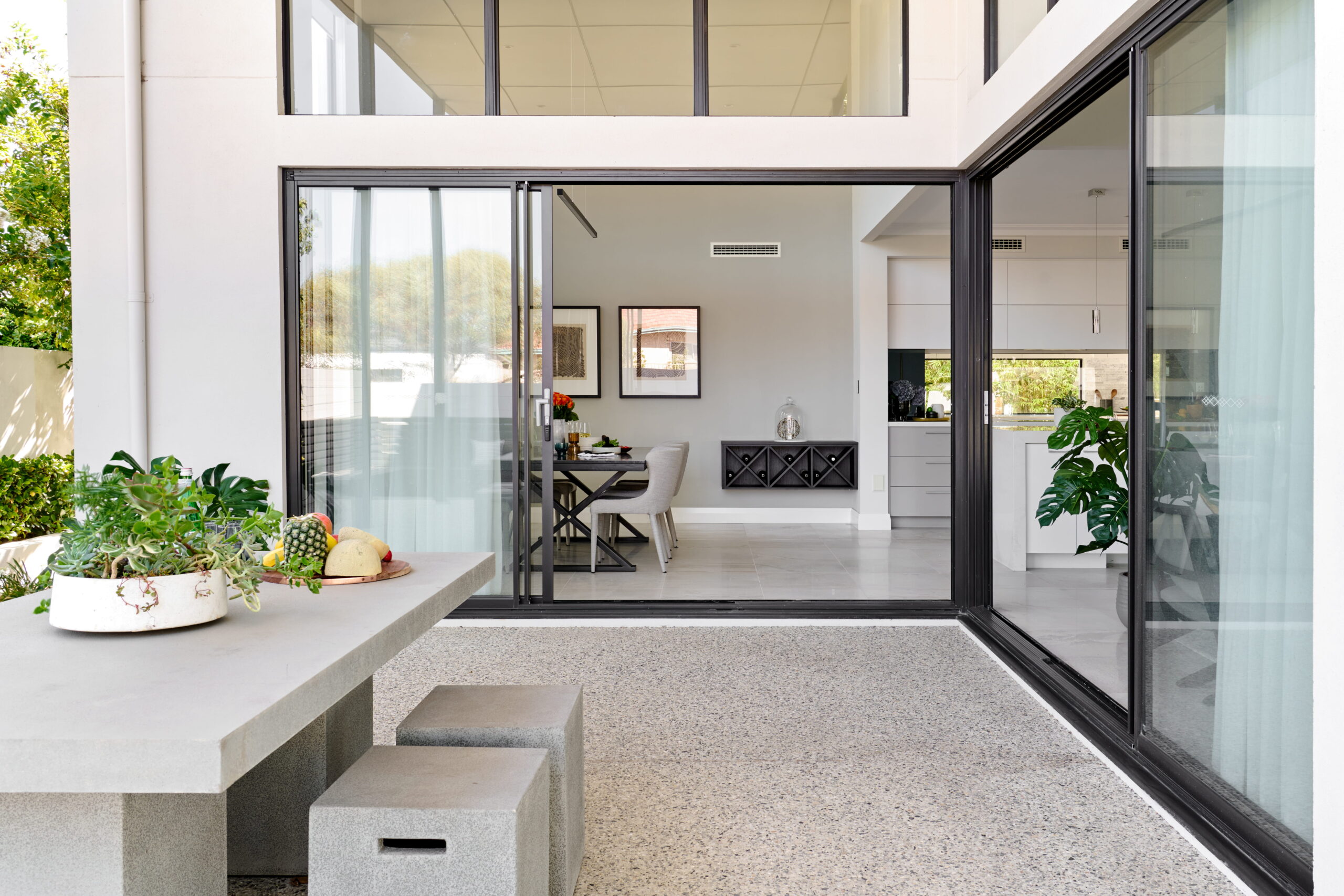 Outdoor alfresco with flush threshold and full-width glazing connecting to open-plan dining and kitchen
