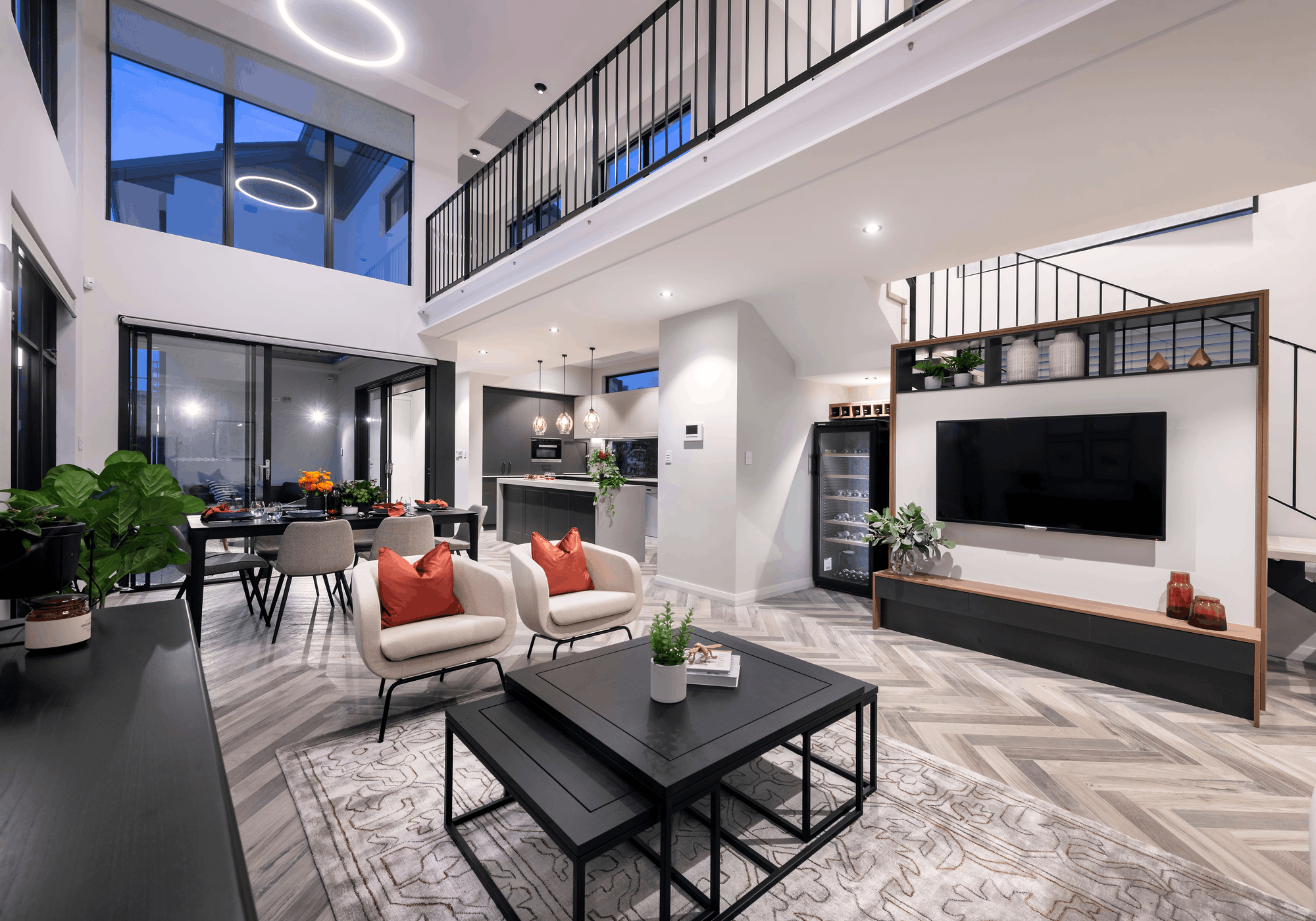 A spacious, modern open-plan living room and kitchen with a high ceiling, showcasing seamless and comfortable luxury interior design.